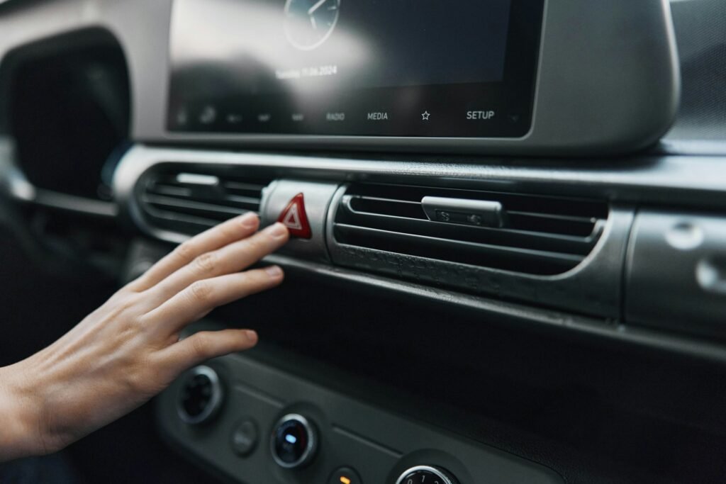 Car air conditioning control a person adjusting an air vent with a red arrow highlighting the center