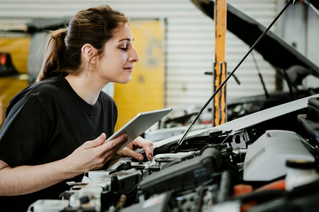 Female mechanic running a diagnostic on a car engine