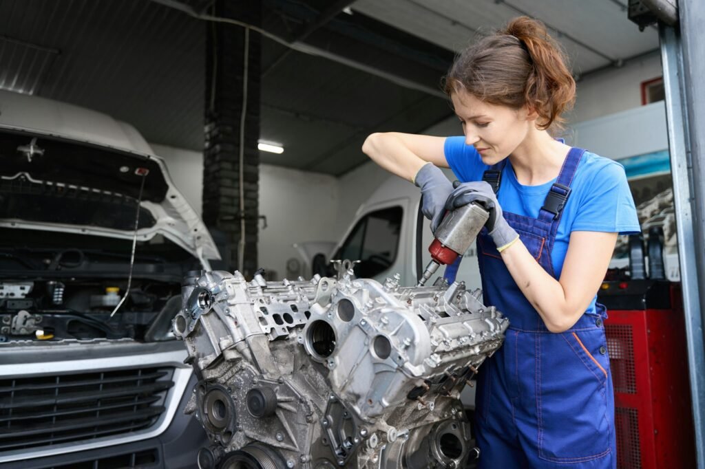 Young woman master repairs a car engine